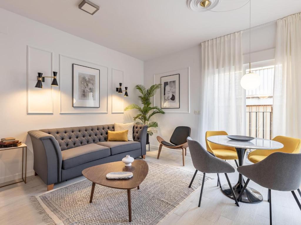 Central Stylish and Elegant 1 & 2 BR apartments I في غرناطة: غرفة معيشة مع أريكة وطاولات وكراسي