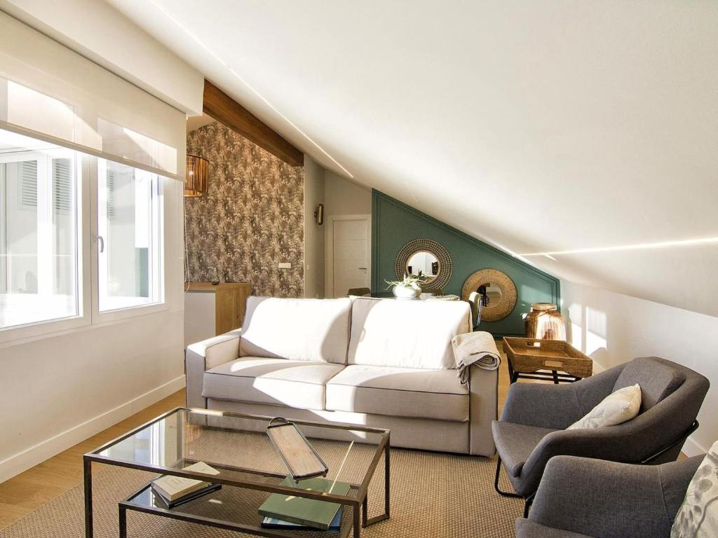 ein Wohnzimmer mit einem weißen Sofa und 2 Stühlen in der Unterkunft Chezmoihomes Premium Loft private terrace in Granada