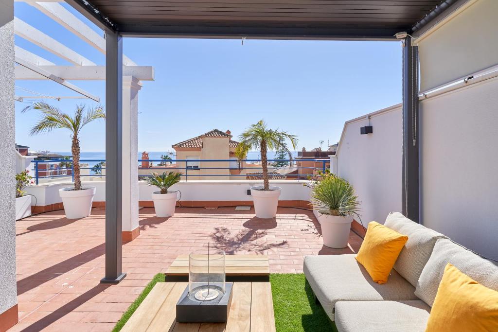 sala de estar con sofá en el balcón en Breathtaking Penthouse Las Azaleas, en Torrox