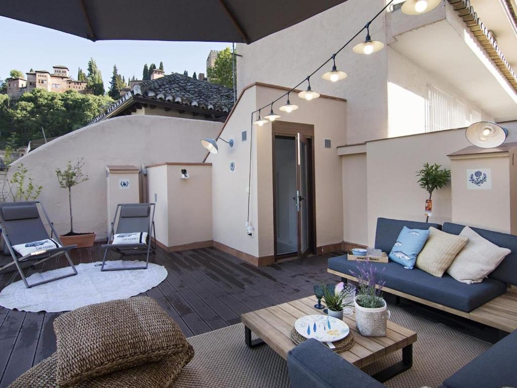 ein Wohnzimmer mit einem blauen Sofa und einem Tisch in der Unterkunft Chezmoihomes Alhambra Boutique Terrace in Granada