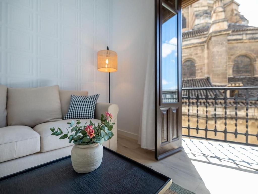 a living room with a couch and a vase with flowers at Bright and Elegant Gran Via apartments in Granada