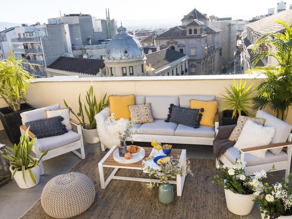 a patio with couches and a table on a balcony at Chezmoihomes Luxury Penthouse in Granada