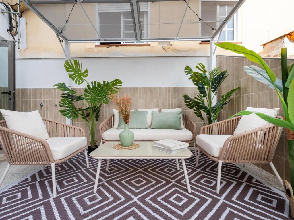 un patio con sofá, 2 sillas y una mesa en San Anton Boutique Terrace, en Granada