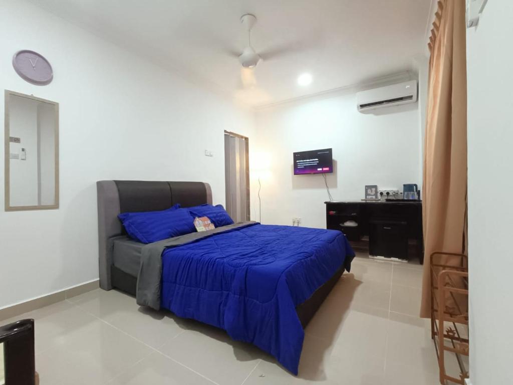 een slaapkamer met een bed met een blauwe deken bij SELESA GUEST RoOM in Skudai