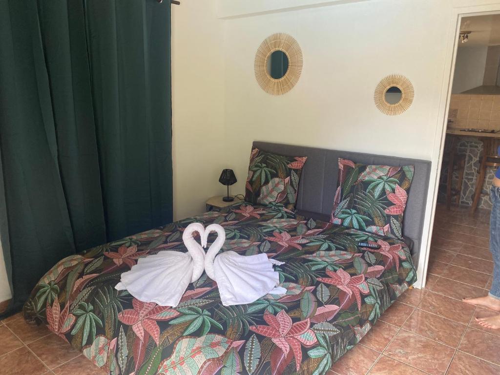 a bedroom with a bed with a bow on it at L'escale chez Kalou in La Rivière