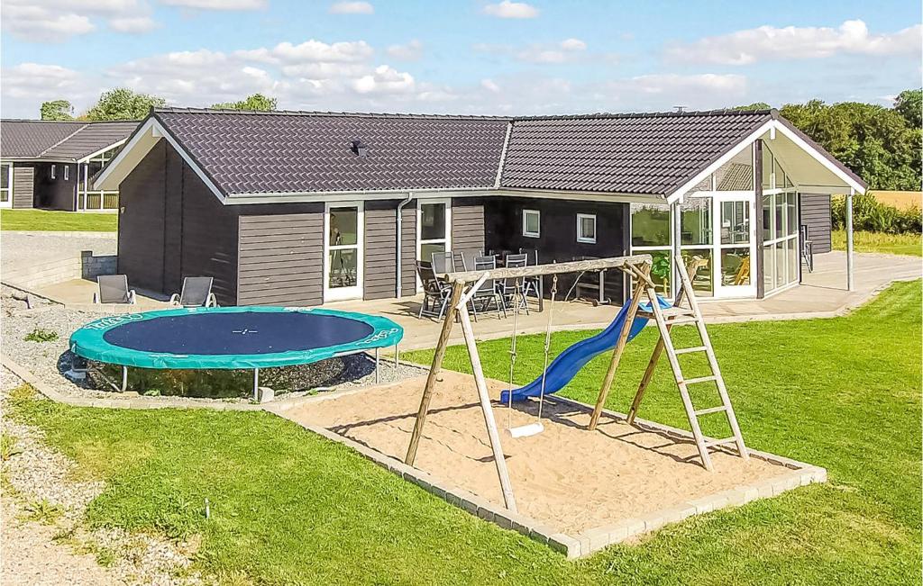 einen Hinterhof mit einem Spielplatz mit Rutsche und einem Haus in der Unterkunft Awesome Home In Haderslev With Wifi in Kelstrup