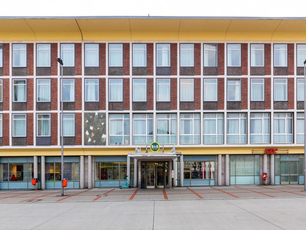 un grand bâtiment en brique avec drapeau américain dans l'établissement B&B HOTEL Bochum-Hbf, à Bochum