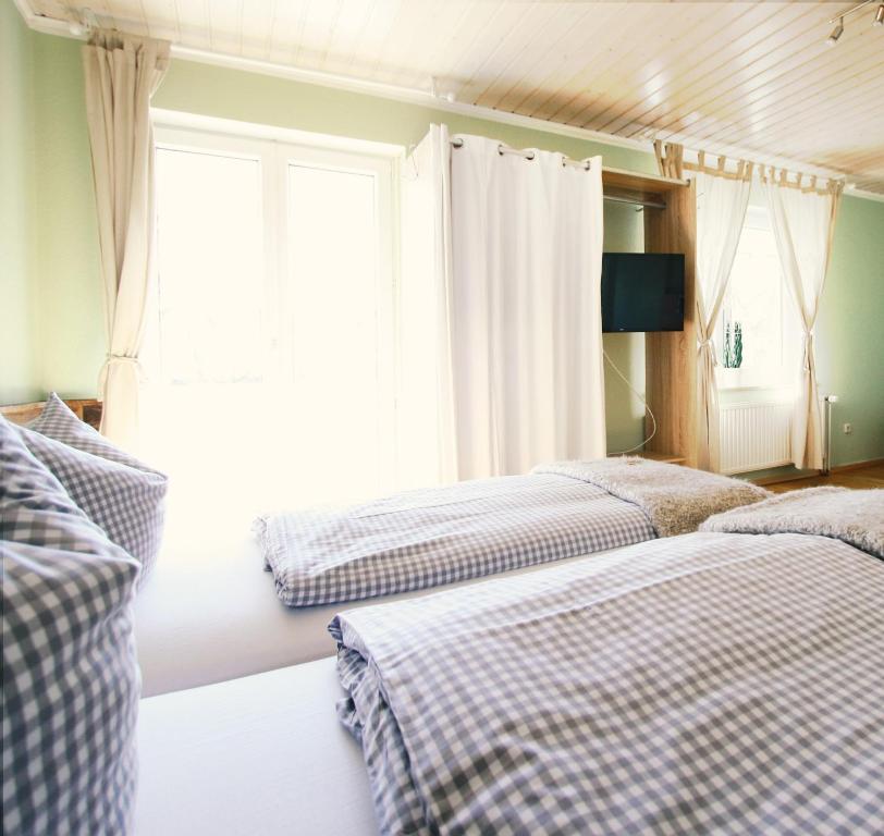 1 Schlafzimmer mit 2 Betten und einem Fenster in der Unterkunft Haus am Bach - gemütliche Frühstückspension in Allershausen