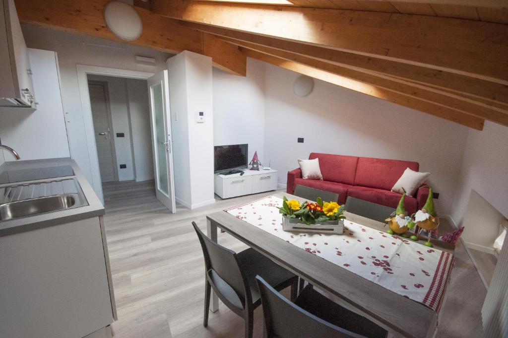 a living room with a table and a red couch at Apt Ochner Strawberry 5 Pergine in Pergine Valsugana