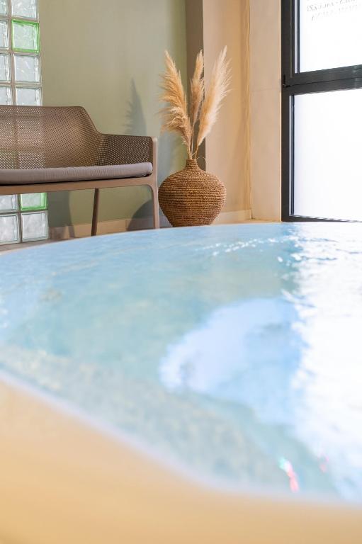 a table in a room with a potted plant at Kyriad Prestige Residence & Spa Cabourg-Dives-sur-Mer in Dives-sur-Mer