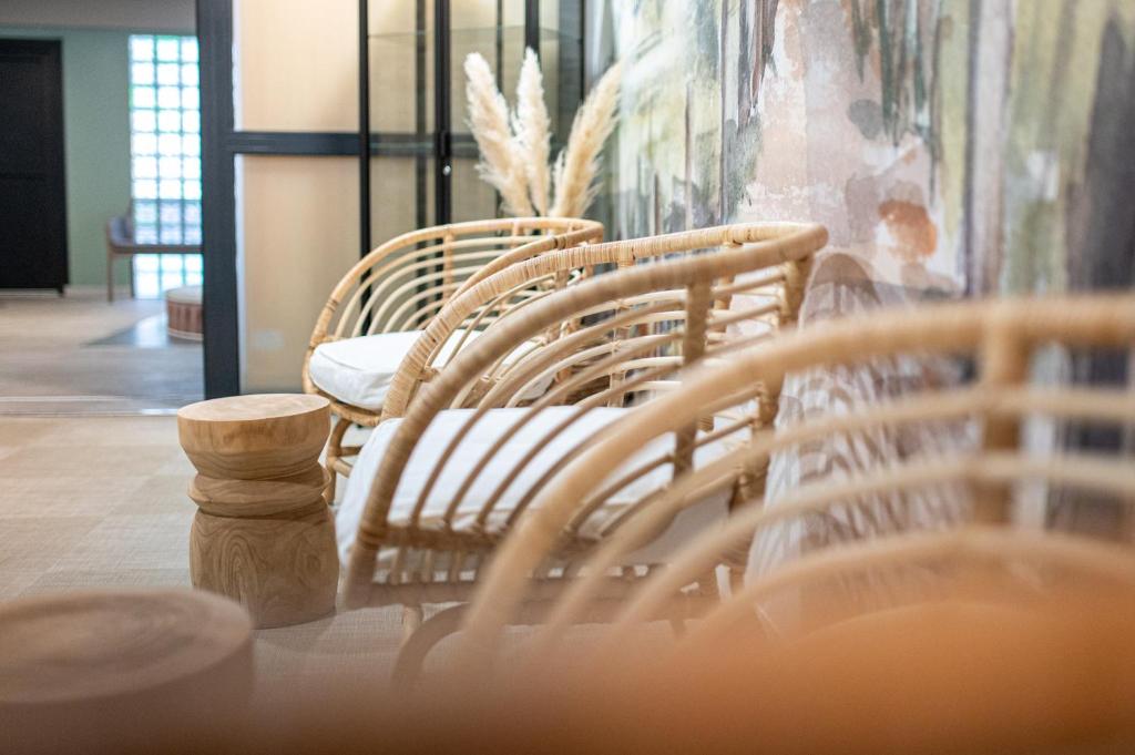 a group of wicker chairs sitting in a room at Kyriad Prestige Residence & Spa Cabourg-Dives-sur-Mer in Dives-sur-Mer