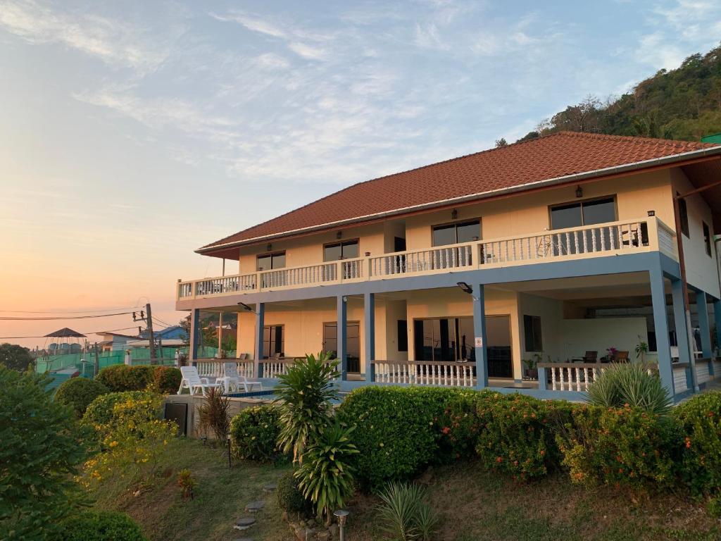 a house with a balcony on the side of it at Scan House Apartment in Karon Beach