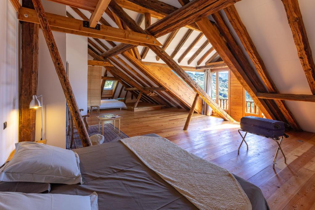 a bedroom with a bed in a room with wooden beams at La Ferme de Beauté in Chateauroux-les-Alpes