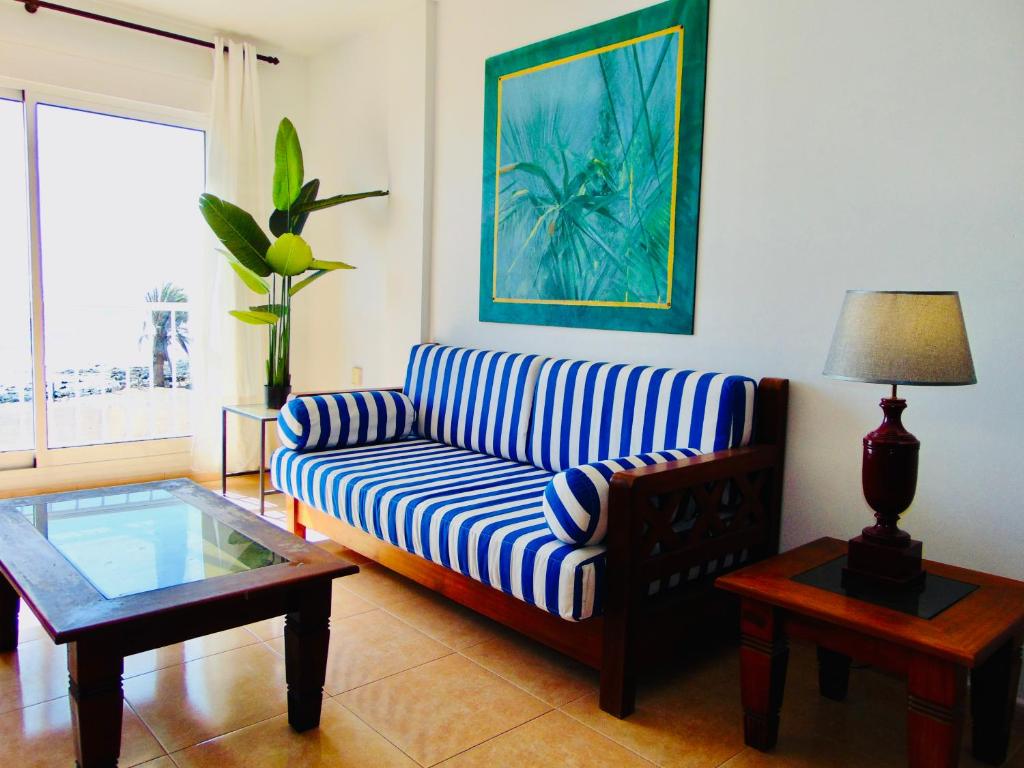 un soggiorno con tavolo e divano bianco e blu di Brisa Del Mar Fuerteventura a Puerto del Rosario