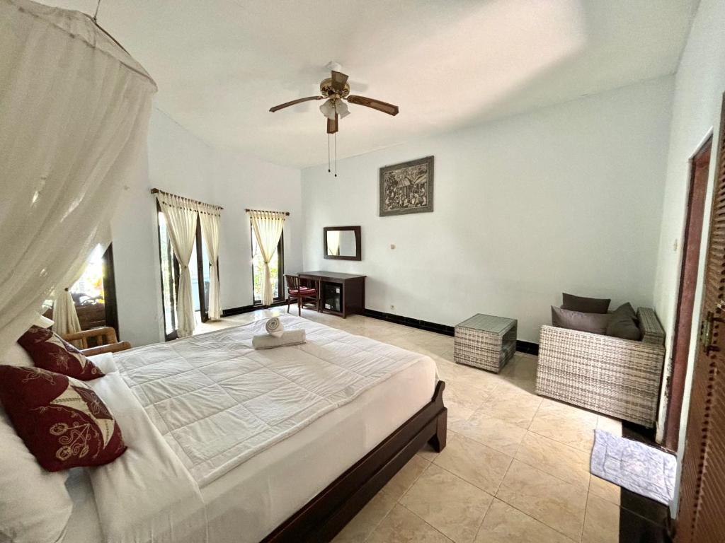 una camera con letto e ventilatore a soffitto di Bahari Beach Amed ad Amed