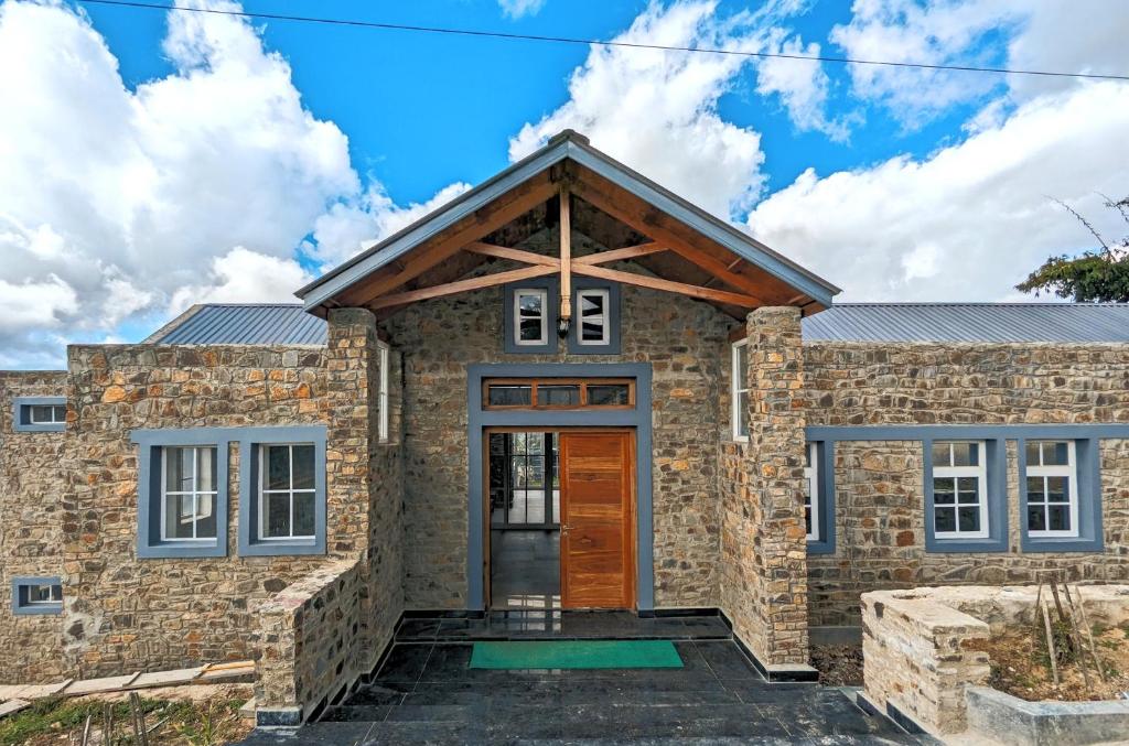 Casa de piedra con puerta de madera en The Wolorim Manor, en Ukhrul