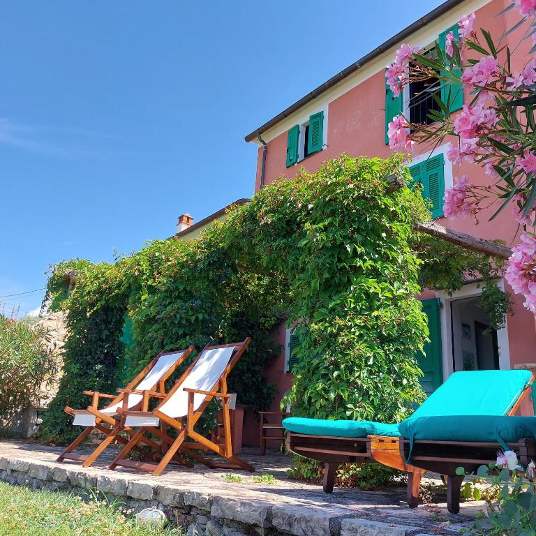 a group of lounge chairs and a house at Miralunga Villetta Rossa in Lerici