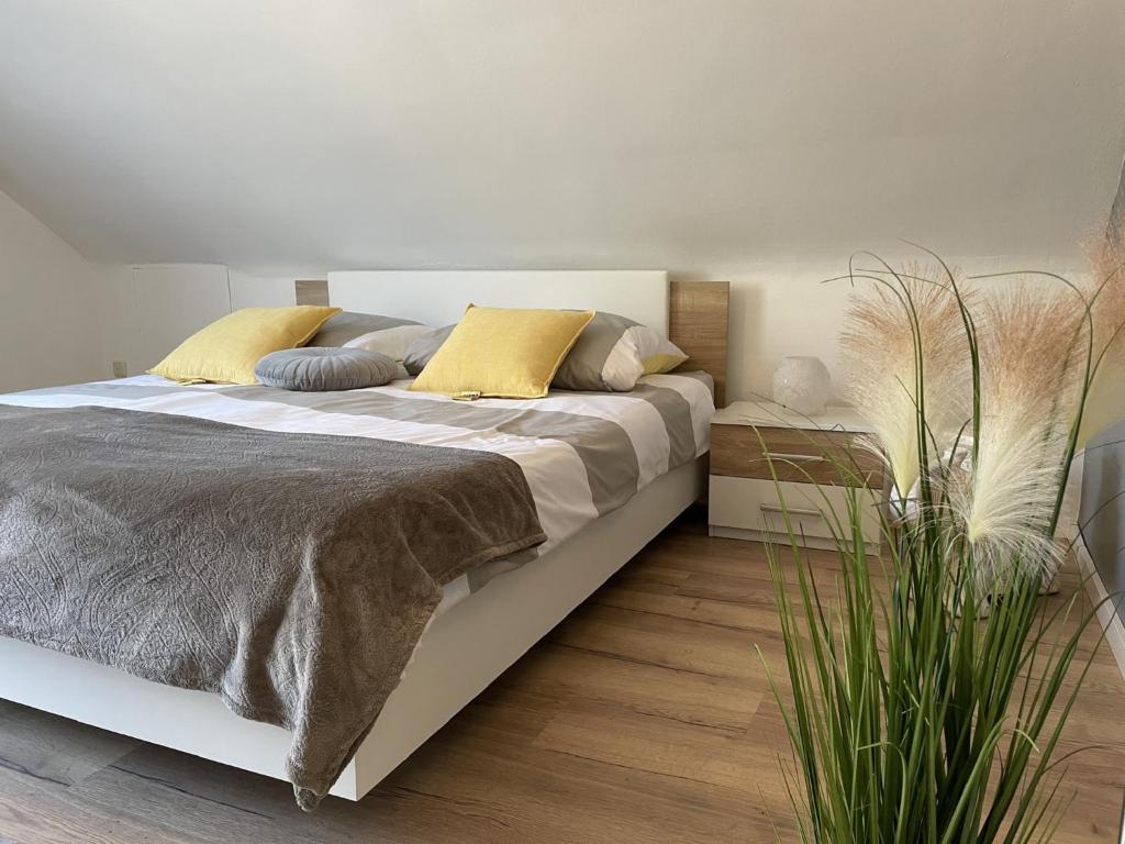 - une chambre avec un grand lit blanc et des oreillers jaunes dans l'établissement Ferienwohnung am Goldberg, à Schauenstein