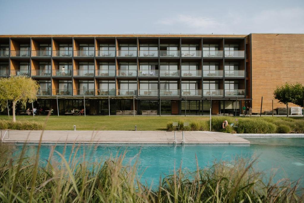 an external view of a building with a pool in front at Empordà Golf Resort in Torroella de Montgrí