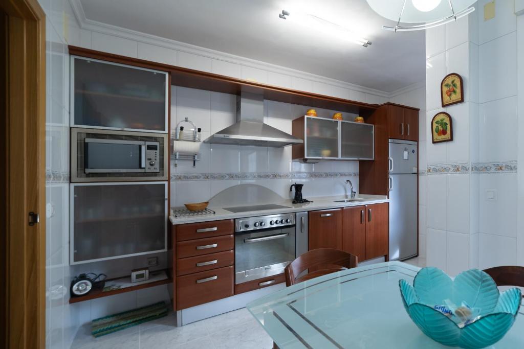 a kitchen with stainless steel appliances and a glass table at Puente de Hierro in Zamora