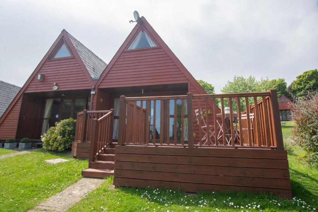 a small house with a deck and a porch at Chalet 99 in Deal