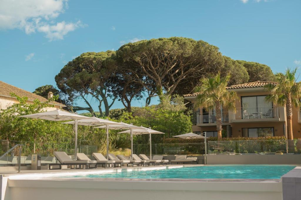 a resort swimming pool with chairs and umbrellas at Kube Saint-Tropez in Saint-Tropez