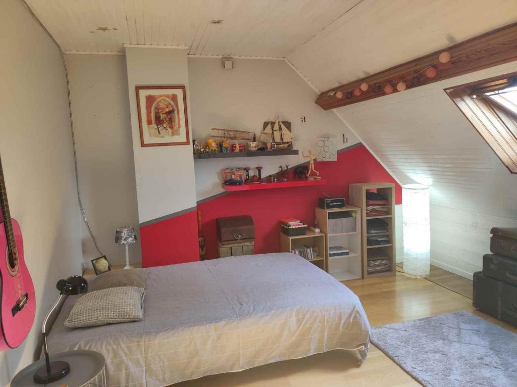 1 dormitorio con cama y pared roja en Chambre proche paris JO 2024, en Chaumontel