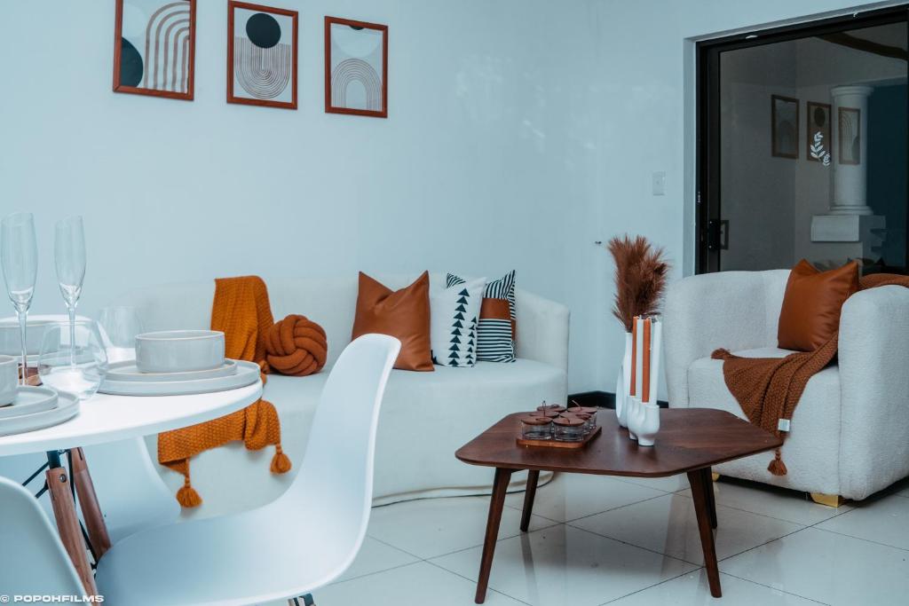 a living room with a white couch and a table at La Casa De Made-Luxury Apartment-No loadshedding in Sandton
