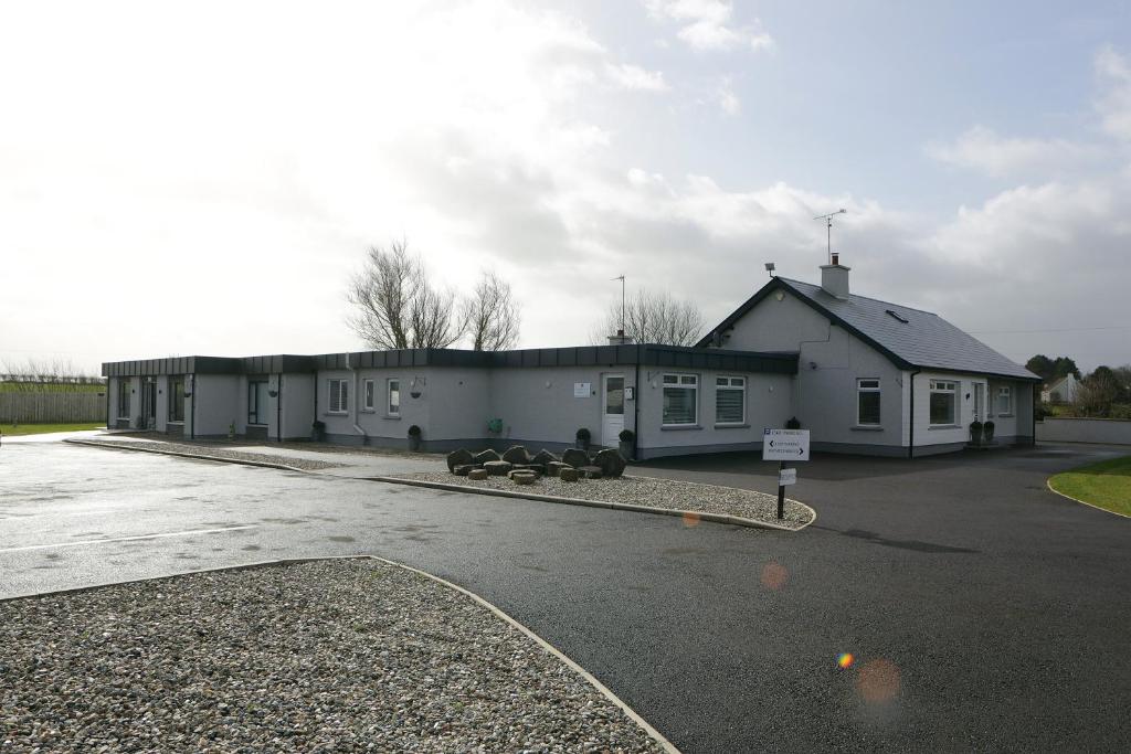 un edificio con vacas estacionadas en un estacionamiento en Causeway B&B, en Bushmills