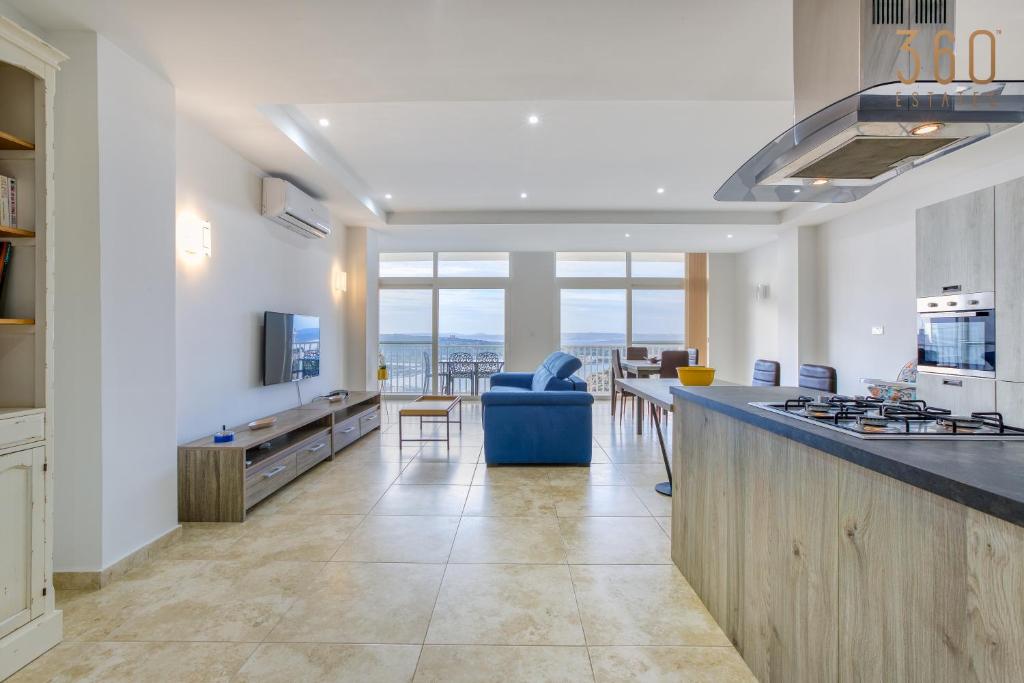 una cucina e un soggiorno con vista sull'oceano di Top of the world 2BR home with spectacular views by 360 Estates a Mellieħa