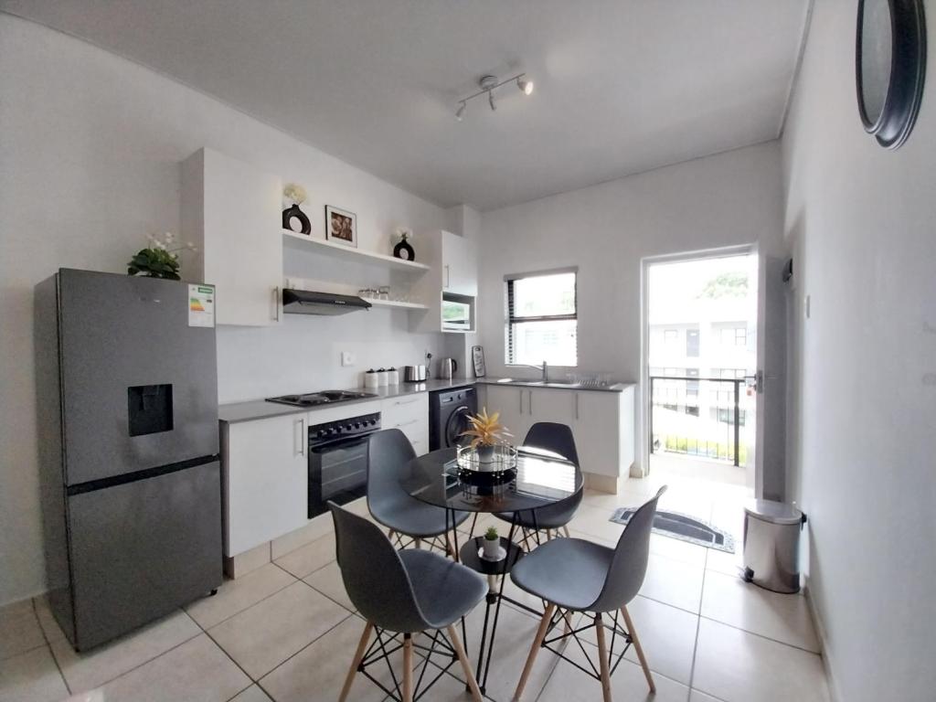a kitchen with a table and chairs in a room at 931 Ballito Groves in Ballito