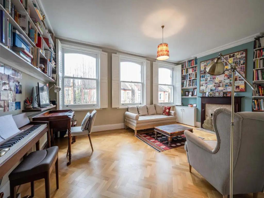 a living room with a piano and a couch at Pass the Keys Stylish London Flat near Station - Victoria 20 min in London
