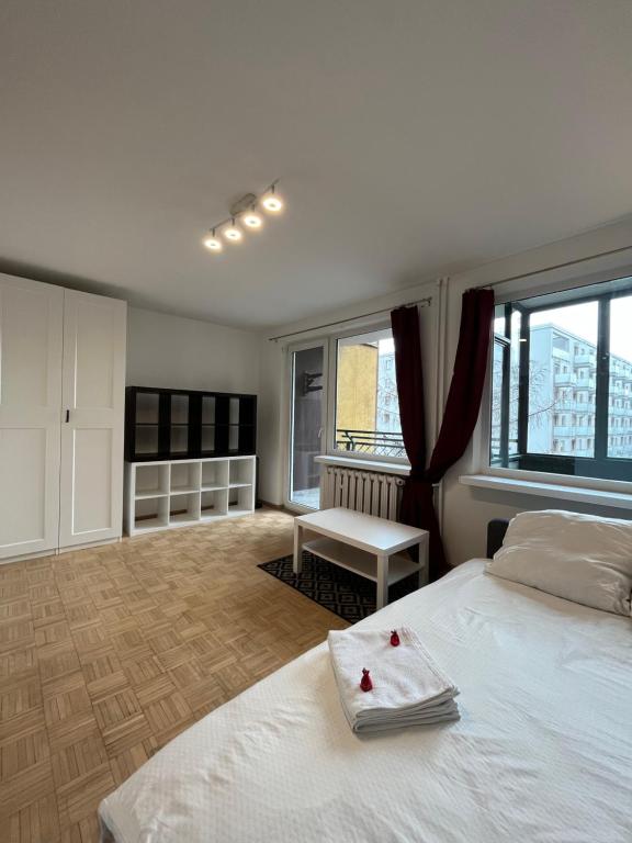 a bedroom with a large white bed and windows at BEMA Guest House - City Centre in Wrocław