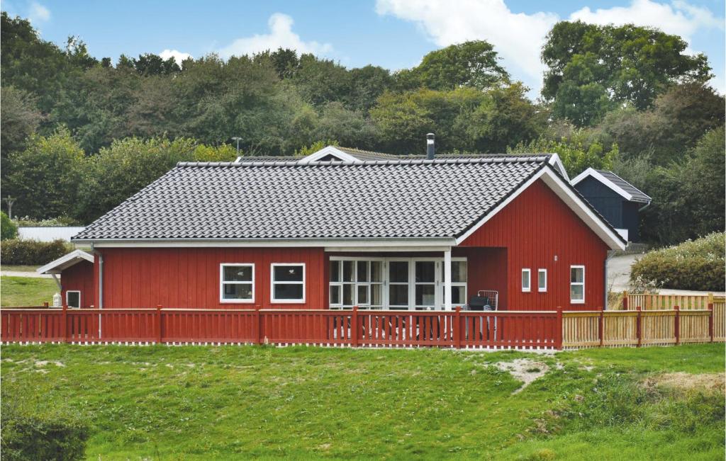 ノーポにあるAwesome Home In Nordborg With 3 Bedrooms, Sauna And Wifiの野原の柵付き赤い家