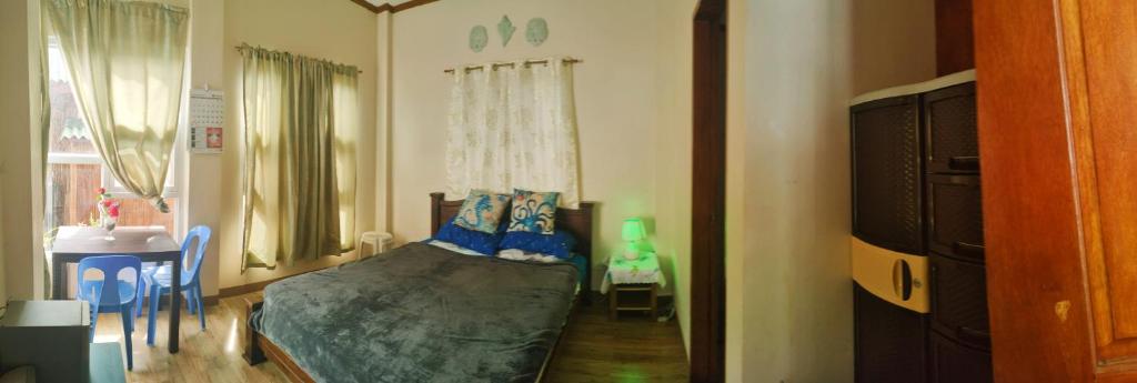 a bedroom with a bed with blue pillows on it at Puerto Galera Transient Guest Room in Puerto Galera