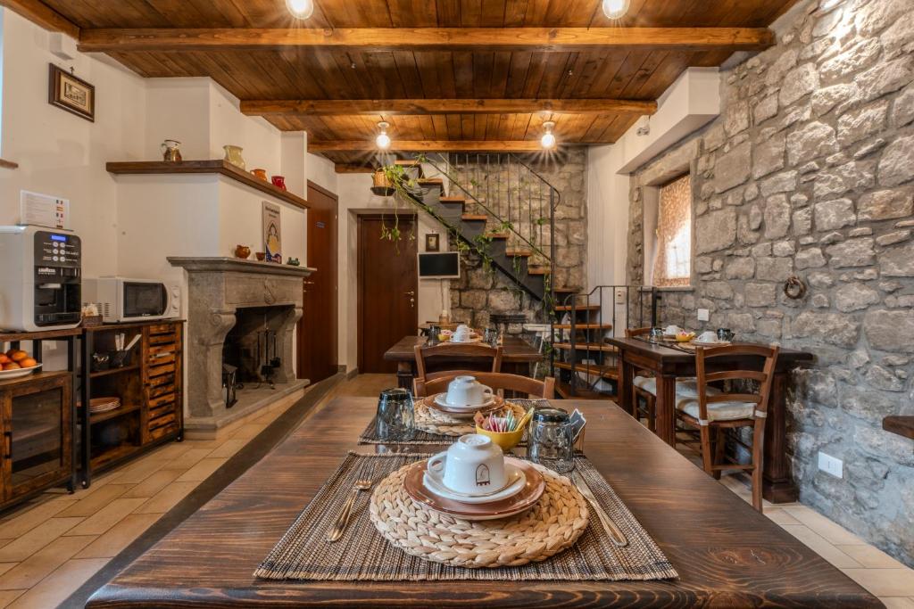 IL RICHIASTRO MEDIEVALE في فِتيربو: غرفة طعام مع طاولة وجدار حجري