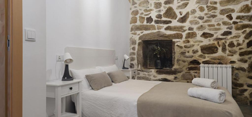 una camera da letto con un letto e un muro di pietra di Casa do Rio - AL a Valença