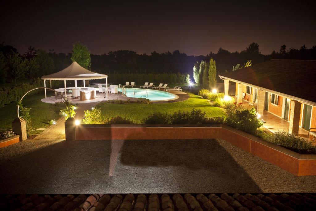 a backyard with a pool and a gazebo at night at Agriturismo Ai Casoni in Codognè