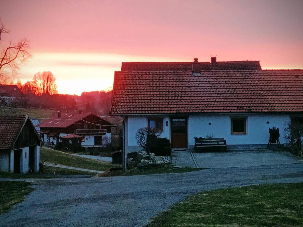 une maison blanche avec un toit rouge dans une rue dans l'établissement Hartl Hof, à Breitenberg