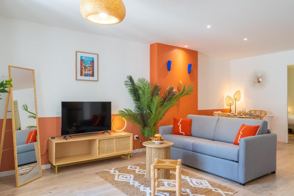 un salon avec un canapé bleu et une télévision dans l'établissement Les 3 Cigales - Bel appartement proche vieux port, à Marseille