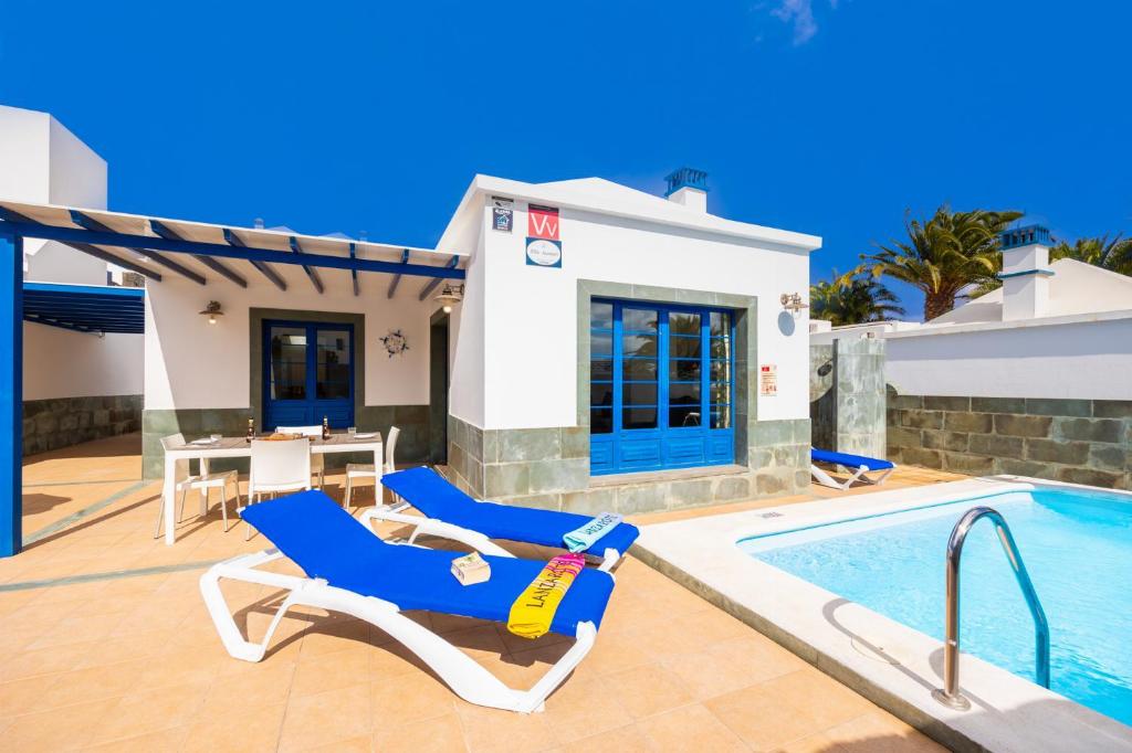 a villa with a swimming pool and a house at Villa Acomari in Playa Blanca