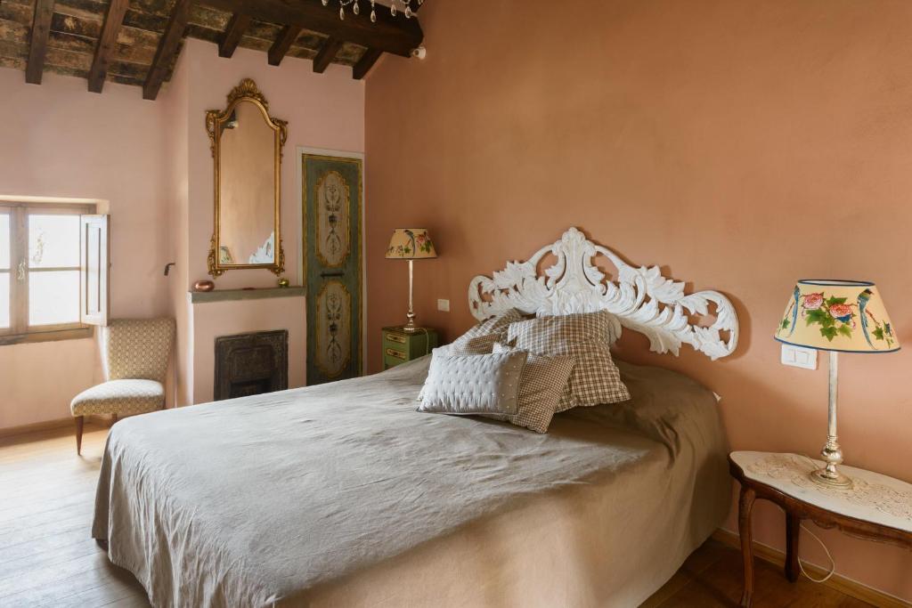 ein Schlafzimmer mit einem Bett und einem Tisch mit einer Lampe in der Unterkunft Casa Mia A Cortona in Cortona