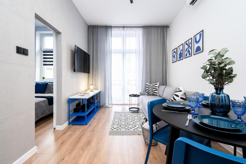 a living room with a blue couch and a table at Apartament Indygo16 in Kalisz