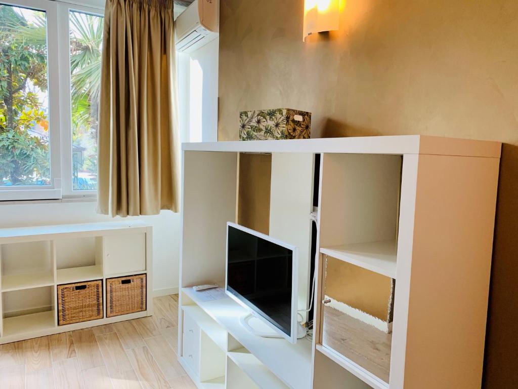 a living room with a tv in a white cabinet at Front Lake 2 Bardolino in Bardolino