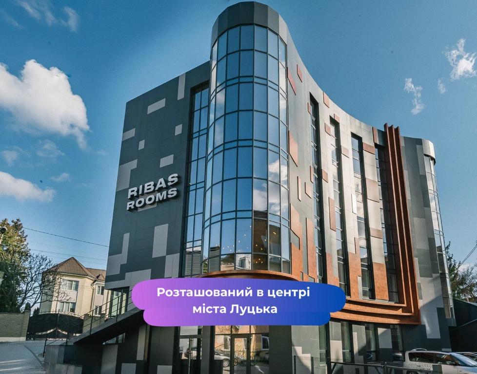 a building with a sign in front of it at Ribas Rooms Lutsk in Lutsk