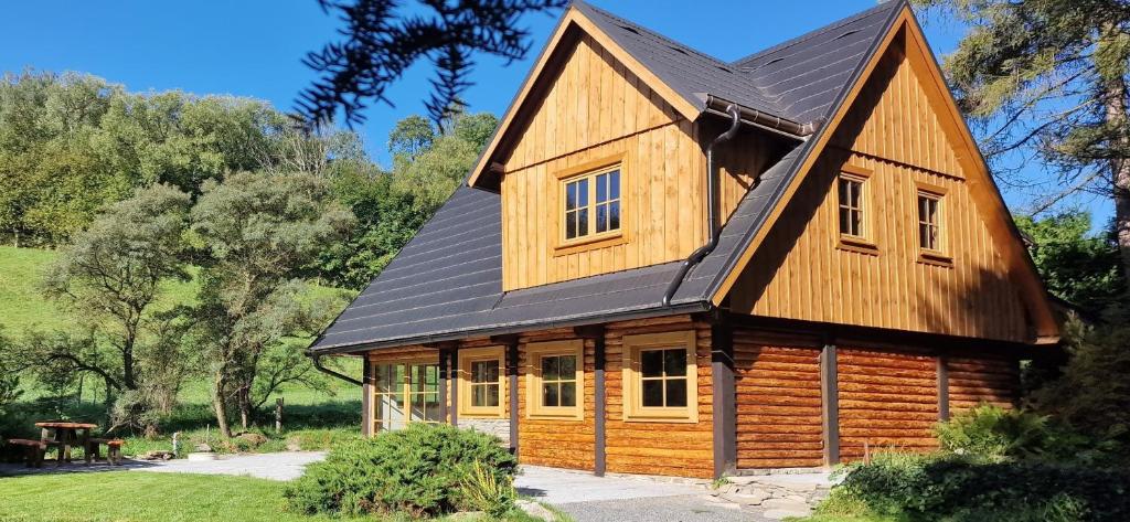 a log cabin with a black roof at Srubová Chata Tis in Heřmanovice