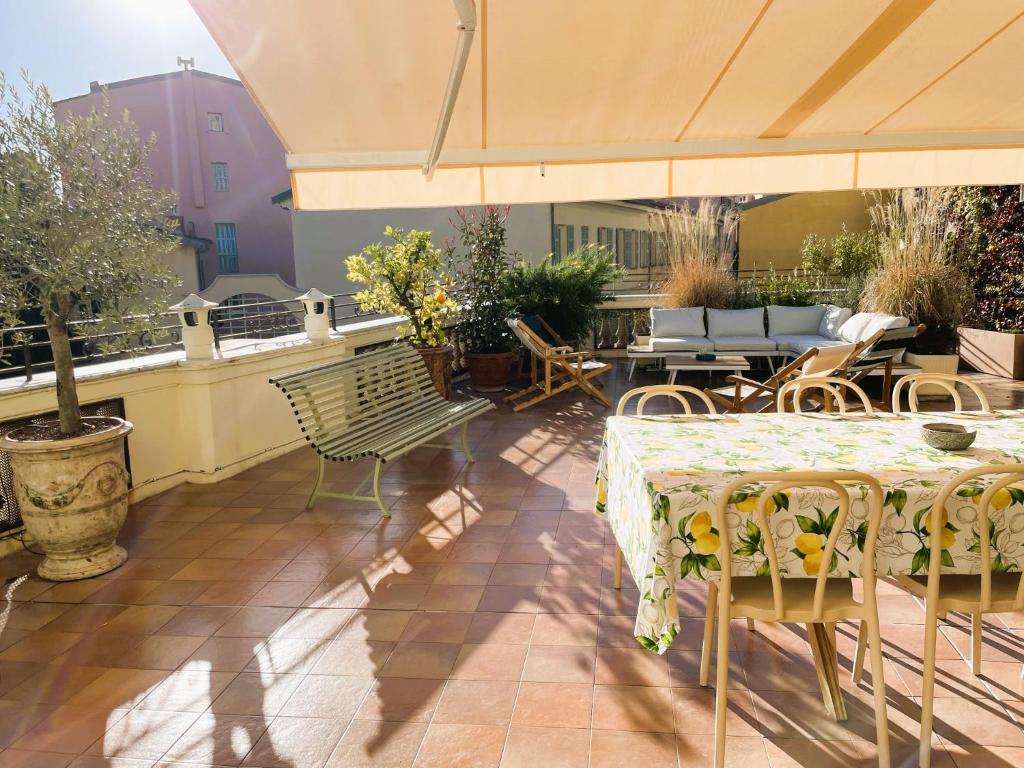 een patio met een tafel en stoelen en een parasol bij Maison Trenca in Menton