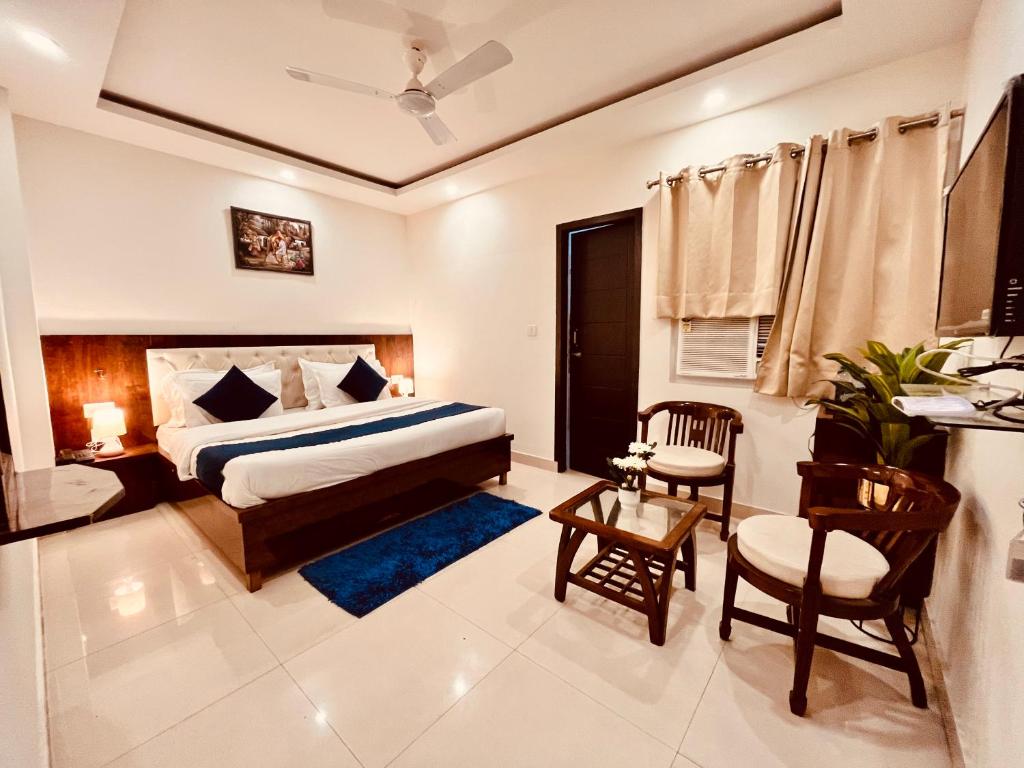 um quarto com uma cama, uma mesa e cadeiras em The Pacific Grand Haridwar em Haridwār
