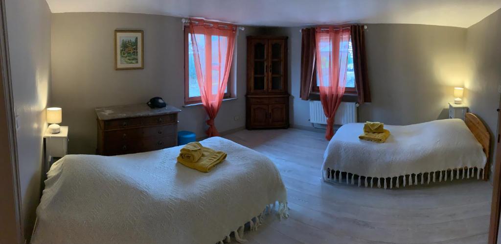 - une chambre avec 2 lits et des rideaux rouges dans l'établissement Ferme alsacienne, à Soppe-le-Haut