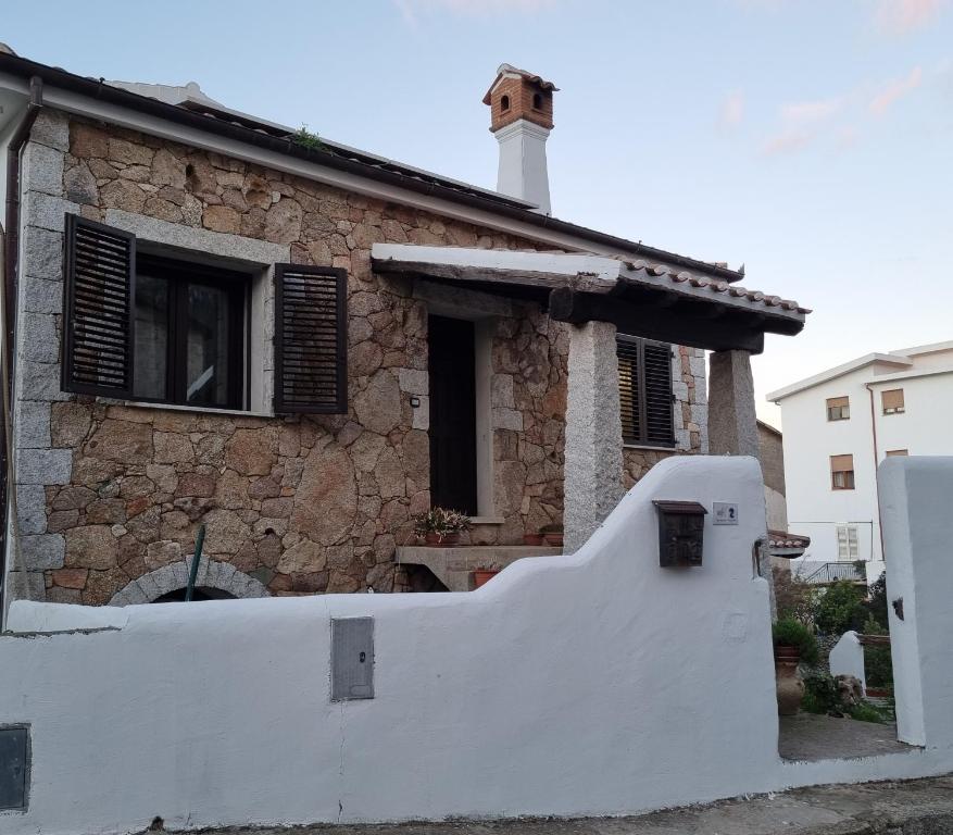 Casa Oliena في أوليينا: سور أبيض أمام المنزل